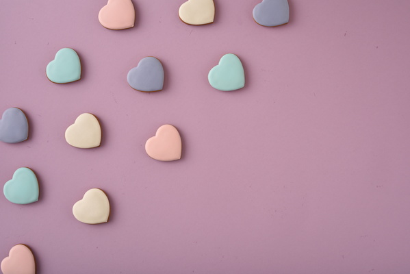 Multicolored Heart-Shaped Cookies Lie on Purple Background